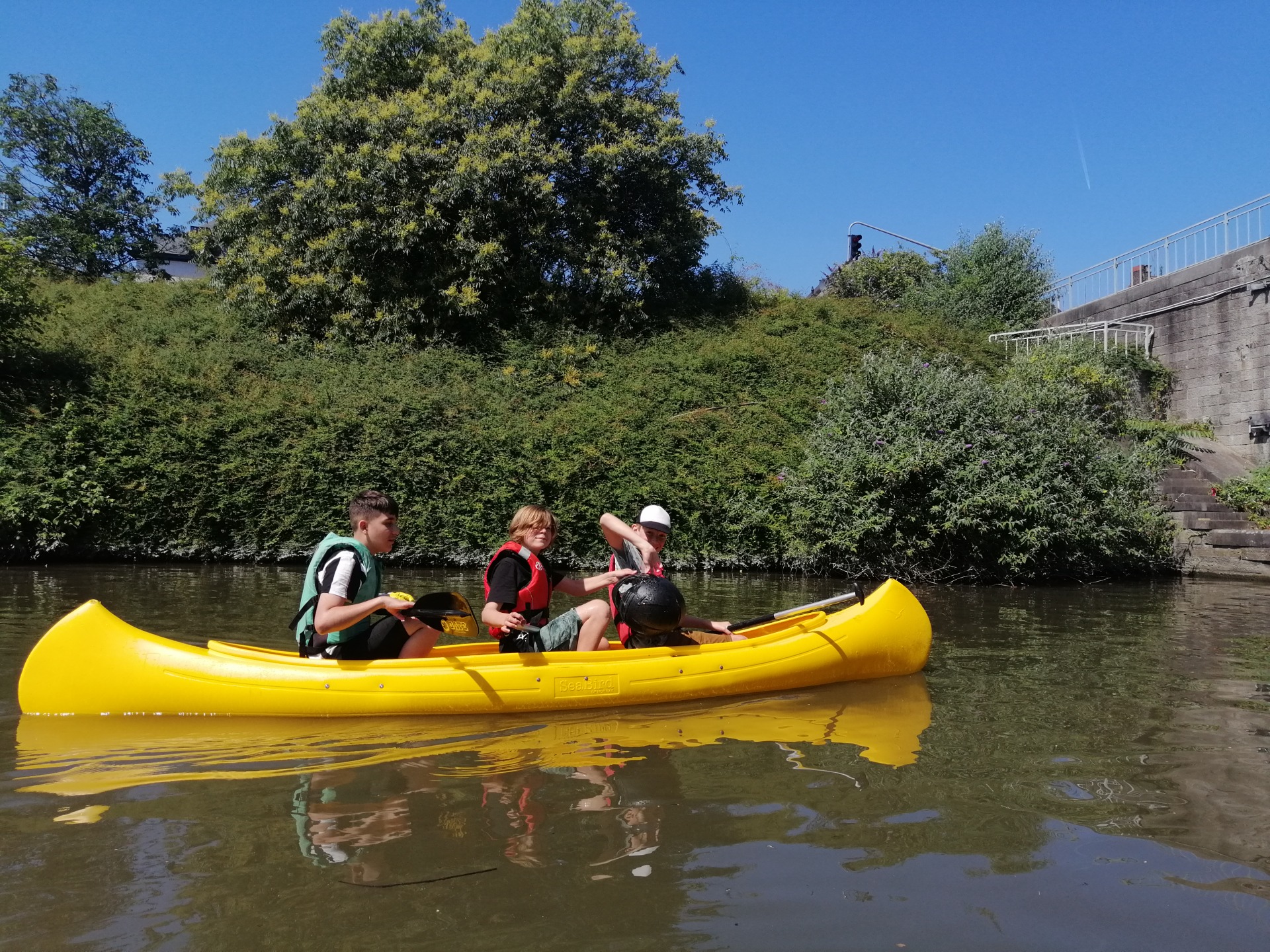Drie jongeren in een kano